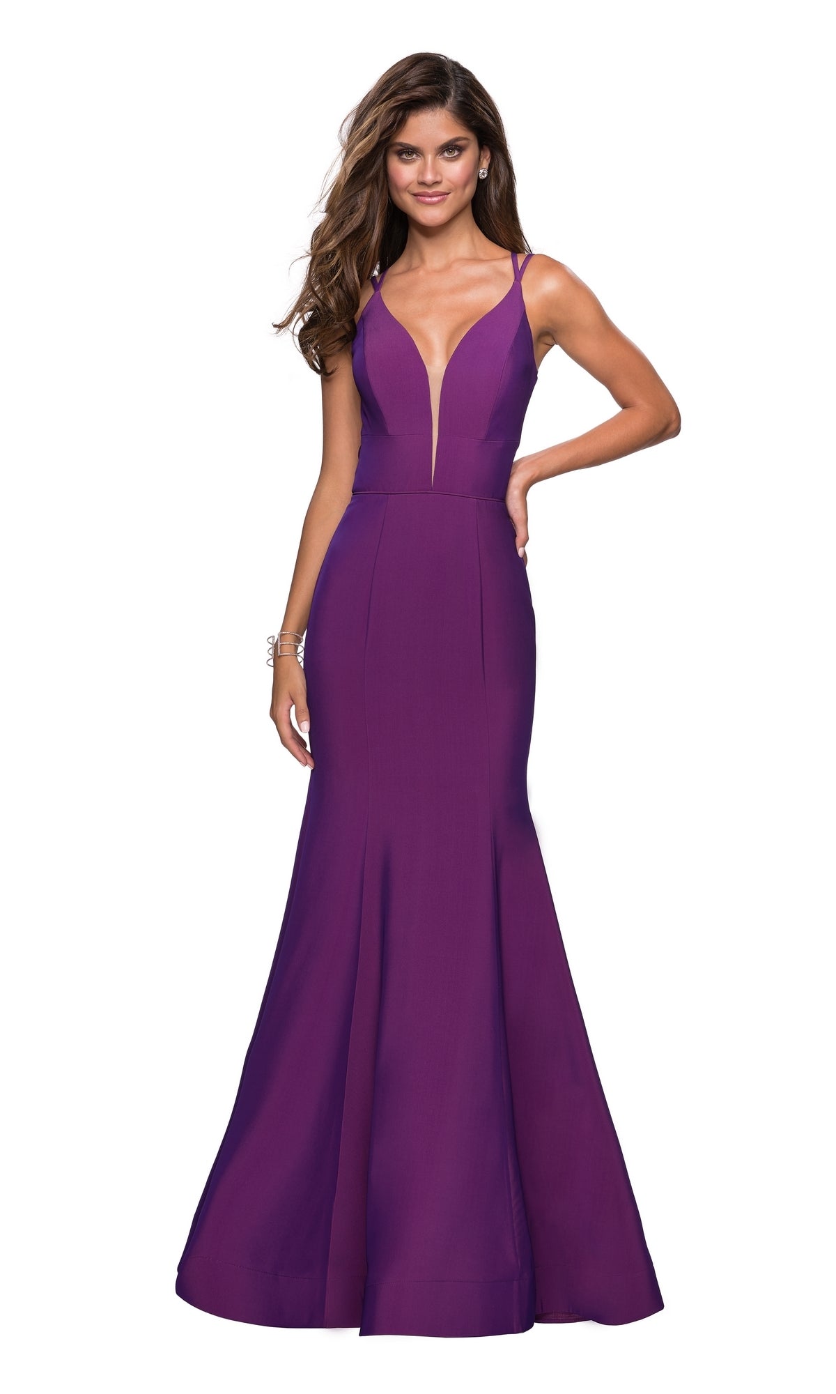 A woman poses against a white background wearing the La Femme Open-Back V-Neck Jersey Prom Dress 27446, a sleeveless, floor-length purple mermaid dress with double spaghetti straps and a deep V-neckline.